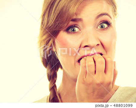 Scared, stressed woman biting her nails Scared, stressed woman biting her nails 48801099