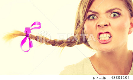 Teenage girl in braid hair making angry face 48801102