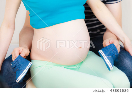 Couple expecting baby, man playing with little shoes Couple expecting baby, man playing with little shoes 48801686