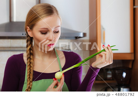 Woman in kitchen holds green fresh chive Woman in kitchen holds green fresh chive 48801792