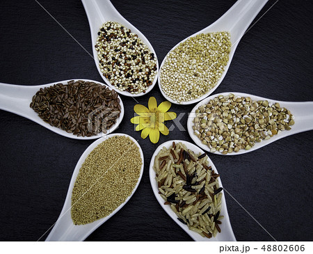 variety of grains on  spoons over black 48802606