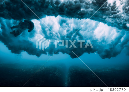 Surfer woman dive underwater under wave 48802770