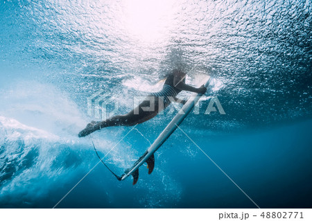 Surfer woman dive underwater under wave 48802771