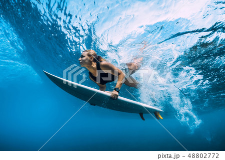 Surfer woman dive underwater under wave 48802772