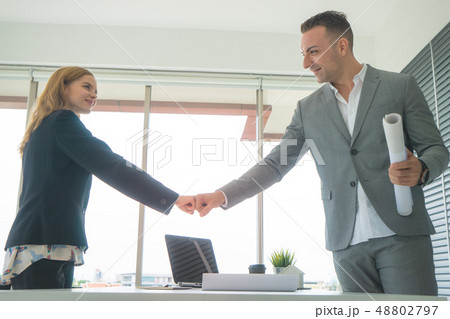 Business man and woman couple fist bump together f 48802797