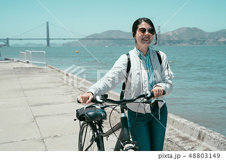 girl walk with bike with golden bridge girl walk with bike with golden bridge 48803149