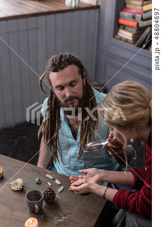 Nice bearded man holding a spoon with liquid 48804697