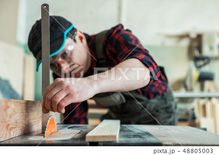 The worker makes measurements of a wooden board 48805003