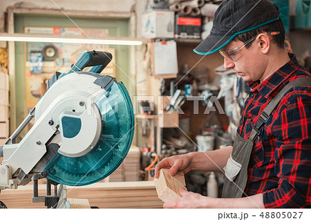Construction worker cutting wooden board 48805027