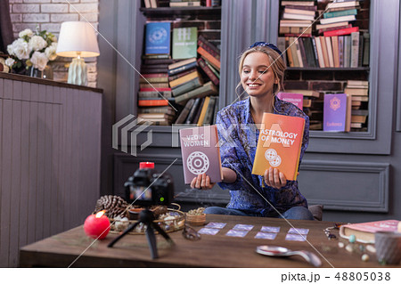 Positive joyful young woman holding two books 48805038
