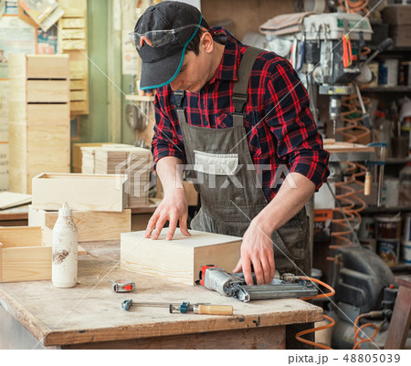 The worker makes measurements of a wooden board The worker makes measurements of a wooden board 48805039