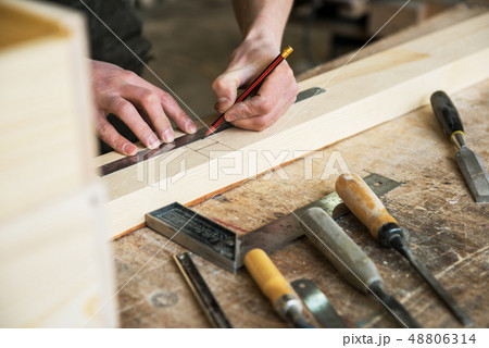 The worker makes measurements of a wooden board 48806314