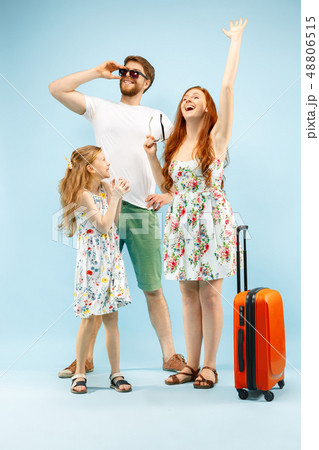 Happy parent with daughter and suitcase at studio isolated on blue background 48806515