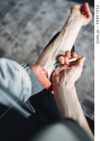 Male person doing an injection dose in the arm Male person doing an injection dose in the arm 48807932