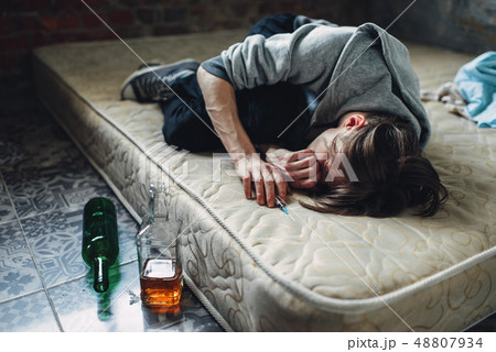 Druggy sleeping, bottle of alcohol is near Druggy sleeping, bottle of alcohol is near 48807934