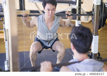 バーベルスクワットで大腿四頭筋を鍛えて太ももを強く鍛えあげる男性インストラクターの写真素材 4037