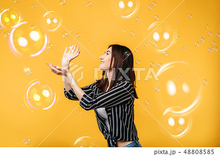 Pretty woman catches soap bubble 48808585
