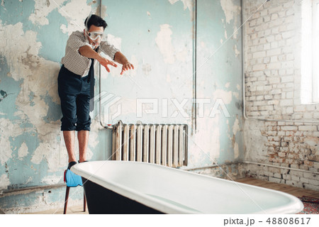 Businessman in flippers dives into the bathtub 48808617