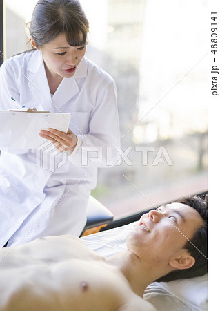 患者と笑顔で会話する白衣の天使女性ナース 48809141