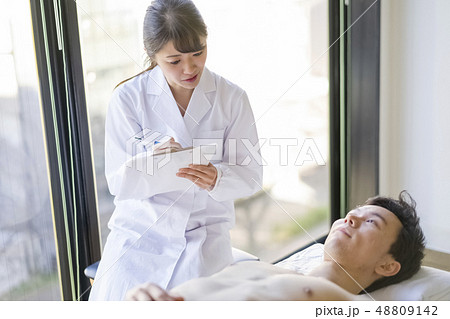 患者と笑顔で会話する可愛い白衣の天使女性研修医 48809142