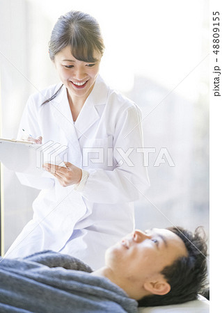 患者と笑顔で会話する白衣の天使女性研修医 患者と笑顔で会話する白衣の天使女性研修医 48809155