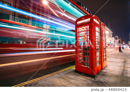 Light trails of a double decker bus next to the iconic telephone booth in London Light trails of a double decker bus next to the iconic telephone booth in London 48809423