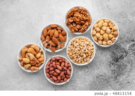 Assortment of nuts in white saucers  48813158