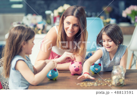 Happy Family mom daughter save money piggy bank Happy Family mom daughter save money piggy bank 48813591