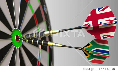 Flags of the United Kingdom and South Africa on darts hitting bullseye of the target. International 48816130