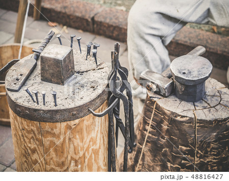 Metalworking tools of blacksmith. The hammer and the anvil and other tools outdoor green grass 48816427