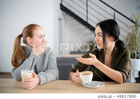 Two young women argue in cafe while drinking coffee 48817880