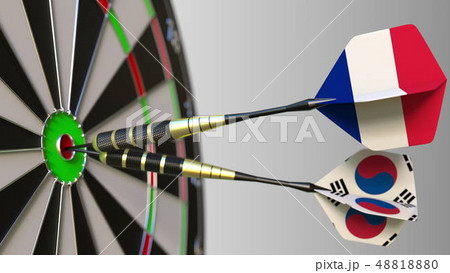 Flags of France and Korea on darts hitting bullseye of the target. International cooperation or Flags of France and Korea on darts hitting bullseye of the target. International cooperation or 48818880