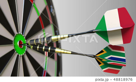 Flags of Italy and South Africa on darts hitting bullseye of the target. International cooperation 48818976
