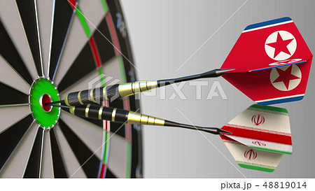 Flags of North Korea and Iran on darts hitting bullseye of the target. International cooperation or 48819014