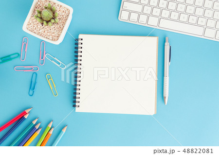Blank notebook with keyboard and pen on blue Blank notebook with keyboard and pen on blue 48822081