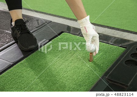ゴルフ練習場で練習をする若い女性手元 48823114