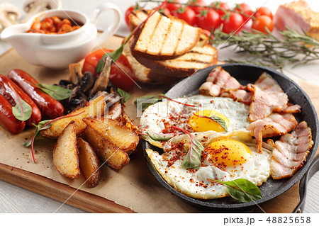 close up of rustic full english breakfast on a white wooden table 48825658