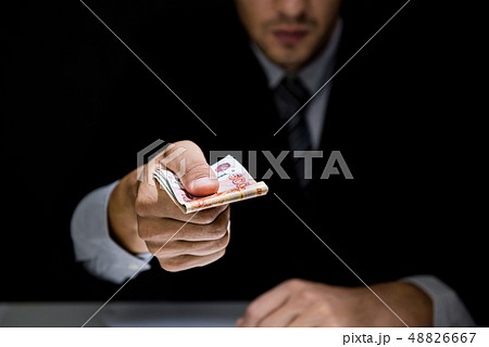Businessman giving bribe money in dark shadow 48826667