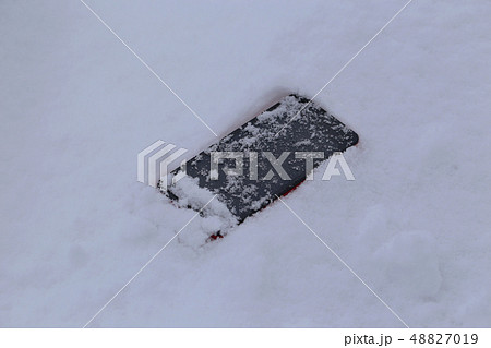 雪に落ちたスマートフォン 48827019