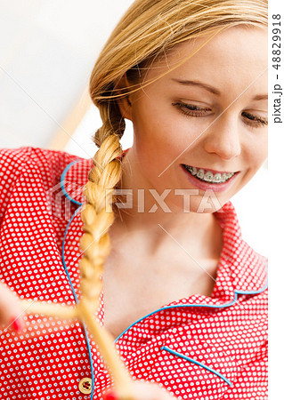 Woman doing braid on blonde hair Woman doing braid on blonde hair 48829918
