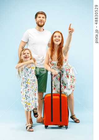 Happy parent with daughter and suitcase at studio isolated on blue background 48830529