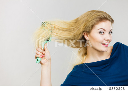 Woman brushing her long hair with brush 48830898