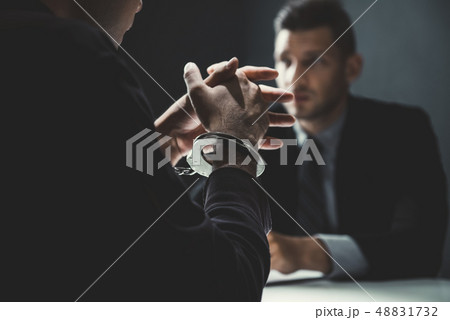 Criminal man with handcuffs being interviewed in 48831732