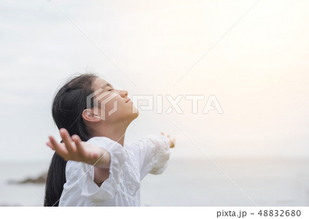 Carefree young girl taking deep breath relaxing 48832680