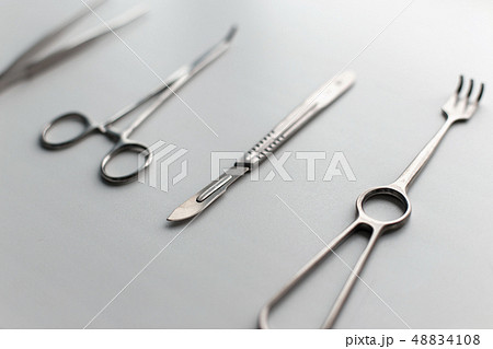 Steel scalpel with medical tools on a white table. 48834108