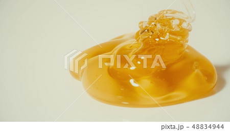 Pouring honey on the plate, macro shot 48834944