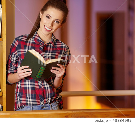 Portrait of a beautiful student in a library Portrait of a beautiful student in a library 48834995