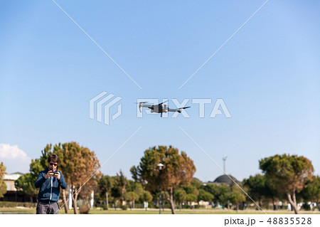 A man piloting a drone in the park in spring-summer time 48835528