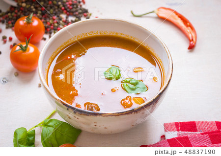 Tomato soup with meat in a white bowl on a white wooden background Tomato soup with meat in a white bowl on a white wooden background 48837190