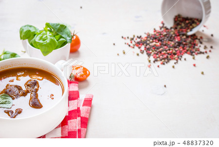 Tomato soup with meat in a white bowl on a white wooden background Tomato soup with meat in a white bowl on a white wooden background 48837320